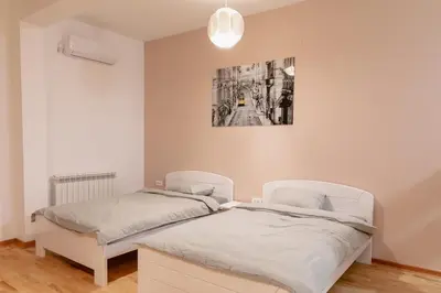 a bedroom with two beds and a painting on the wall at AirMi hotel in Surčin