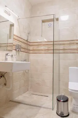 a bathroom with a shower and a sink and a toilet at AirMi hotel in Surčin
