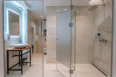 a bathroom with a glass shower and a sink at Alex Central Apartments in Belgrade