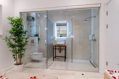 a glass shower in a bathroom with a sink at Alex Central Apartments in Belgrade