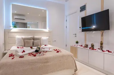 a bedroom with a bed with red flowers on it at Alex Central Apartments in Belgrade