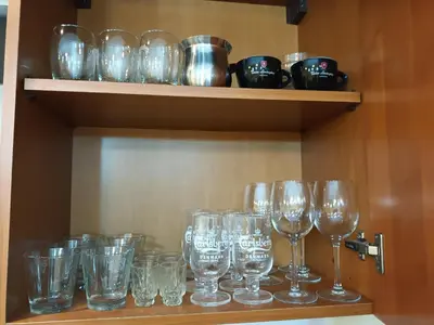 a bunch of wine glasses sitting on a shelf at Apartman Marina in Sajmište