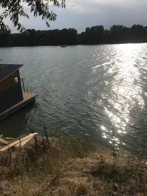 a house on a dock on a large lake at cunami kucica sa bazenom in Belgrade
