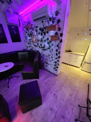 a room with a couch and a table with purple lights at cunami kucica sa bazenom in Belgrade
