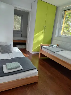 a bedroom with two beds and a green cabinet at Vila Banda in Sremski Karlovci