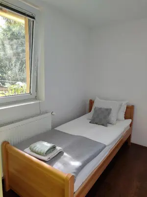 a bed sitting in a room with a window at Vila Banda in Sremski Karlovci