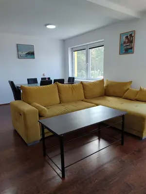 a living room with a yellow couch and a coffee table at Vila Banda in Sremski Karlovci