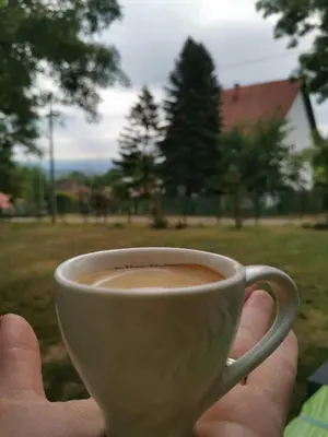 a person holding a cup of coffee in a yard at Sopot Paradise in Sopot