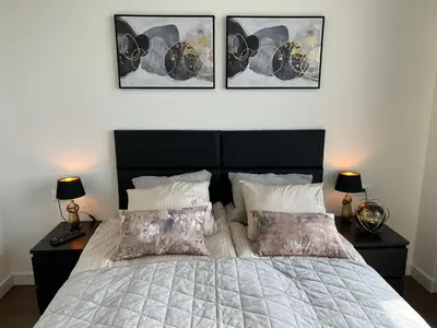 a bedroom with a bed with three pictures on the wall at BW TERRACE top floor apartments with river view & self check-in in Belgrade