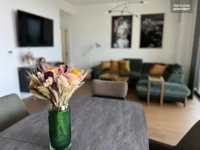 a vase with flowers on a table in a living room at BW TERRACE top floor apartments with river view & self check-in in Belgrade