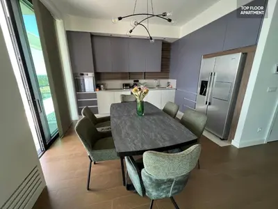 a kitchen with a table with chairs and a refrigerator at BW TERRACE top floor apartments with river view & self check-in in Belgrade