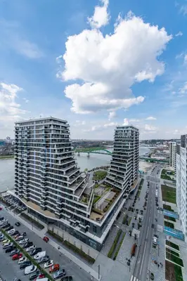 two tall buildings next to a river with a bridge at Modern Apartment in Belgrade Waterfront in Belgrade