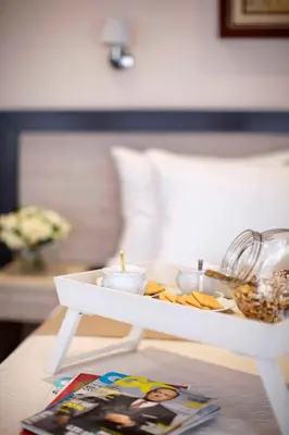 a white tray with food and candles on a table at Garni Hotel Vozarev in Belgrade