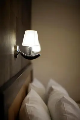 a lamp attached to a wall with pillows at Garni Hotel Vozarev in Belgrade