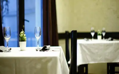 a couple of tables with wine glasses on them at Garni Hotel Vozarev in Belgrade