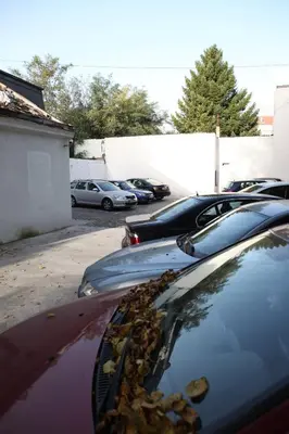 a row of parked cars in a parking lot at Garni Hotel Vozarev in Belgrade