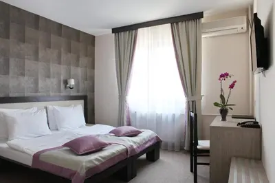 a hotel room with a bed and a window at Garni Hotel Vozarev in Belgrade