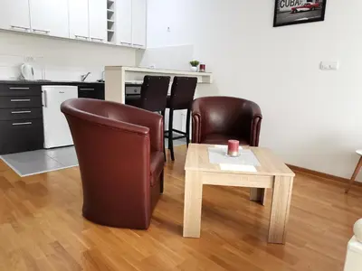 a living room with a table and leather chairs at VIKONT studio apartment with parking 5 eur per day in Belgrade