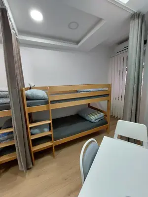 a room with bunk beds and a table and chairs at Hostel Inn Downtown in Belgrade