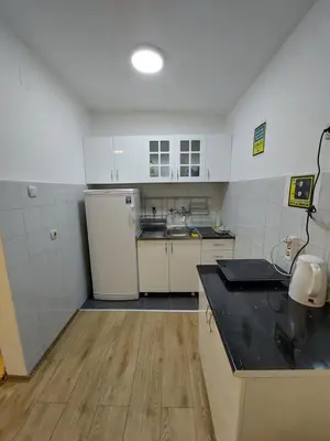 a kitchen with white appliances and a black counter top at Hostel Inn Downtown in Belgrade