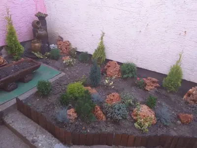 a miniature garden with flowers and plants next to a wall at Verica in Vračar (historical)
