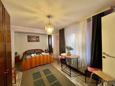 a bedroom with a bed and a table and a dining room at Verica in Vračar (historical)