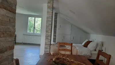 a bedroom with a bed and a table in a room at Green sanctuary 30 min from downtown Belgrade in Donja Ralja