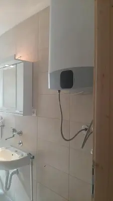 a bathroom with a sink and a tv on the wall at Green sanctuary 30 min from downtown Belgrade in Donja Ralja
