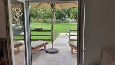 a patio with two benches and an umbrella at Green sanctuary 30 min from downtown Belgrade in Donja Ralja