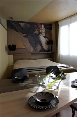 a table in a room with a bed with a painting at Crown apartman in Belgrade