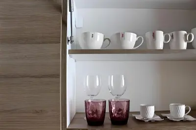 two wine glasses are sitting on a shelf at Crown apartman in Belgrade
