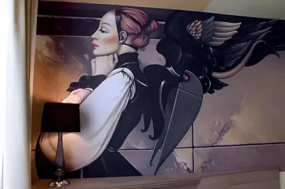 a painting of a woman with a bird on a wall at Crown apartman in Belgrade