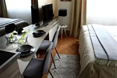 a bedroom with a desk with a computer and a bed at Crown apartman in Belgrade