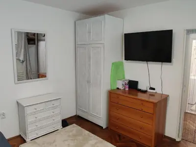 a bedroom with a dresser and a television on a wall at Apartment Miljakovac in Belgrade