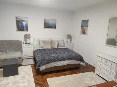 a bedroom with a bed and two dressers at Apartment Miljakovac in Belgrade