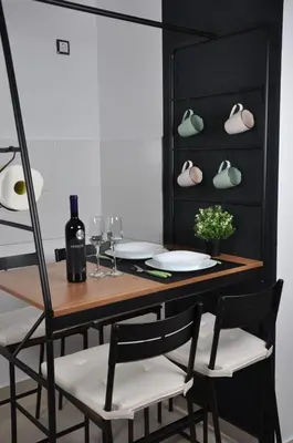 a dining room table with two chairs and a black cabinet at Guest House Atena in Nova Pazova