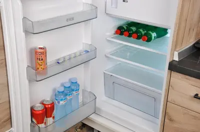 an open refrigerator with drinks and sodas in it at Guest House Atena in Nova Pazova