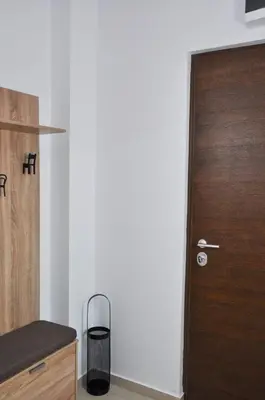a wooden door in a kitchen with a trash can at Guest House Atena in Nova Pazova