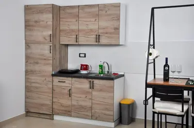 a kitchen with a wooden door and a table at Guest House Atena in Nova Pazova