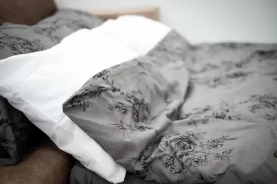 a person laying on a bed under a blanket at Apartman Janković in Arandjelovac