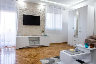 a living room with a tv on a brick wall at Apartman Janković in Arandjelovac