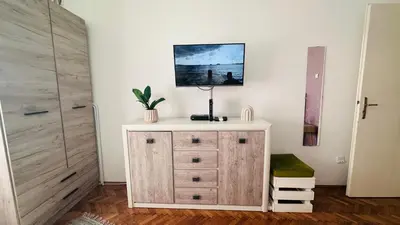 a room with a dresser and a closet with a door at Sweet Venac in Belgrade