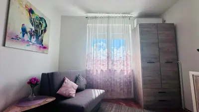 a living room with a couch and a window at Sweet Venac in Belgrade