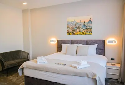 a hotel room with a bed and a chair at Templum Appart-Hotel -SELF CHECK IN - Slavija square in Belgrade