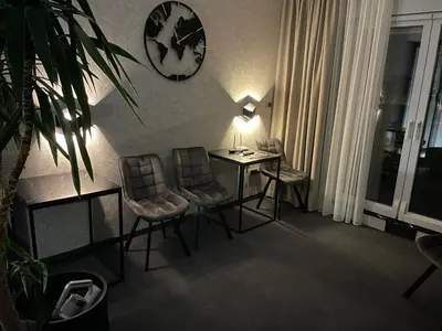 a room with a table and chairs and a clock on the wall at Templum Appart-Hotel -SELF CHECK IN - Slavija square in Belgrade