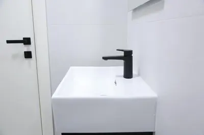 a bathroom sink with a black faucet at Templum Appart-Hotel -SELF CHECK IN - Slavija square in Belgrade