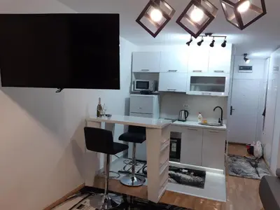 a small kitchen with a desk and a tv on the wall at Zorz in Belgrade