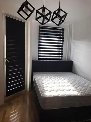 a bedroom with a bed and a window with blinds at Zorz in Belgrade