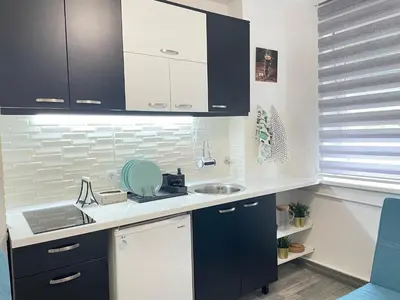 a kitchen with black and white cabinets and a sink at The Blue Velvet Apartment in Belgrade