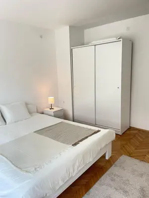 a white bedroom with a large bed and a closet at The Blue Velvet Apartment in Belgrade